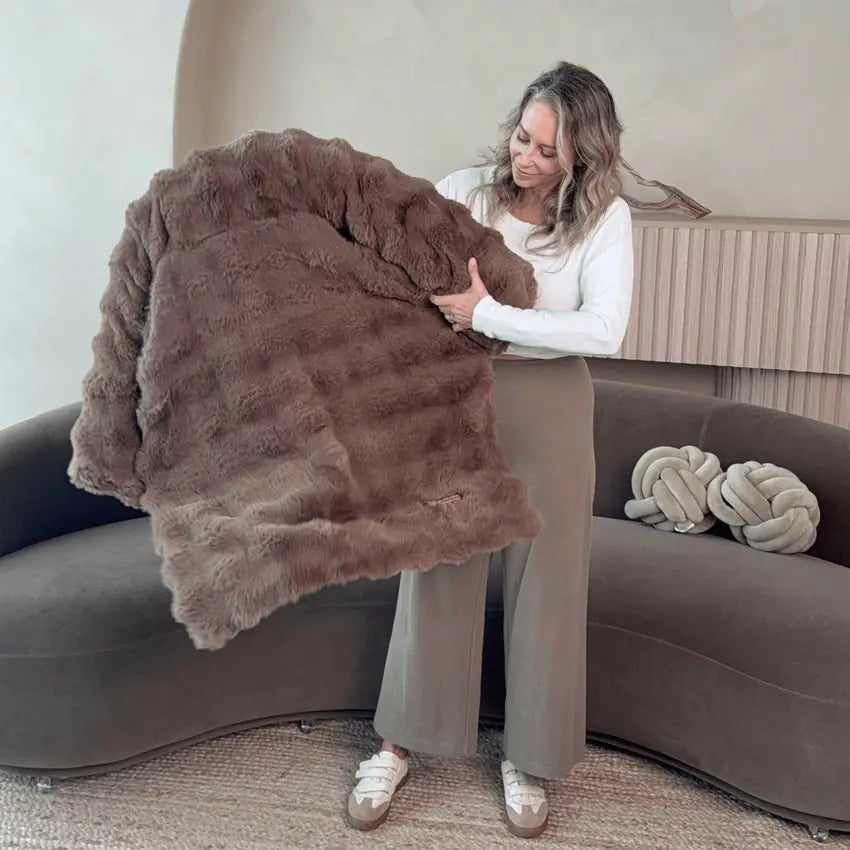 A woman arranging a Pelsbarn sofa bed in her living room